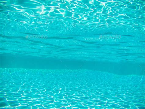 Swimming pool underwater with bright sun light rays or caustics ...