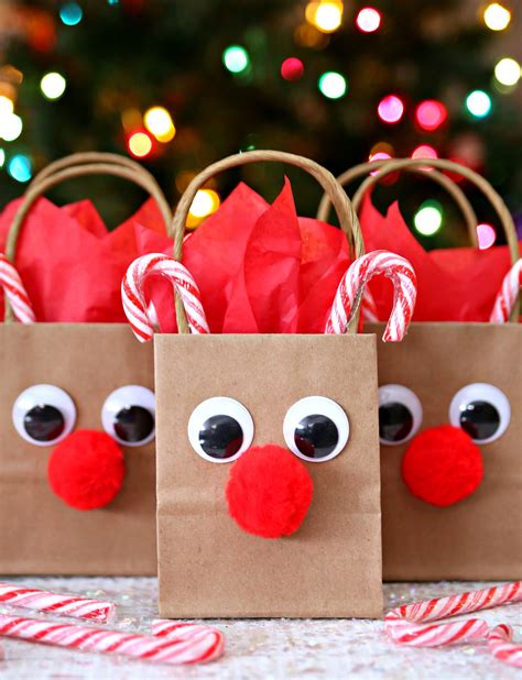 two paper bags with faces and candy canes in front of a christmas tree