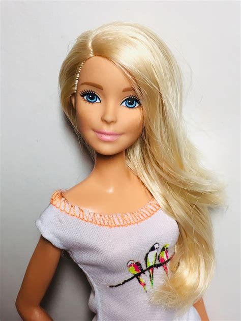 a blonde barbie doll with blue eyes and long hair wearing a white shirt ...