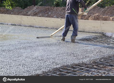 Worker leveling fresh concrete slab with a special working tool Stock ...