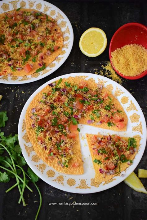 two plates with pizza on them next to some lemon wedges and cilantro