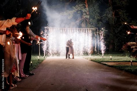 A crowd of young happy people during celebration. Sparkler in hands on ...