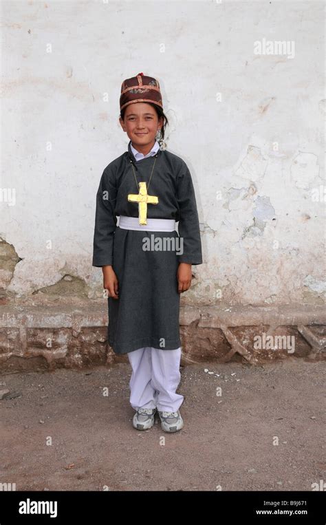 Ladakhi child wearing a traditional costume with a Christian cross, Leh ...