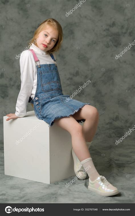 Little girl in a short denim dress. Stock Photo by ©lotosfoto1 352767048