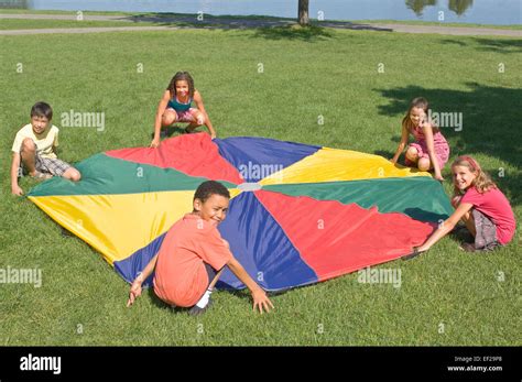 Children playing with a parachute Stock Photo - Alamy