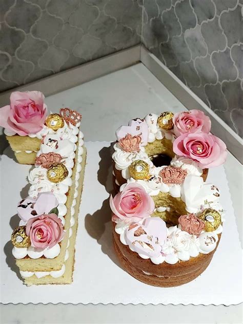 there are two cakes with flowers on the top and one has a letter made ...