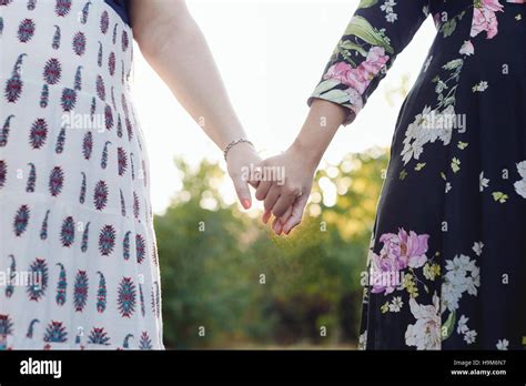 Two best friends holding hands, partial view Stock Photo - Alamy