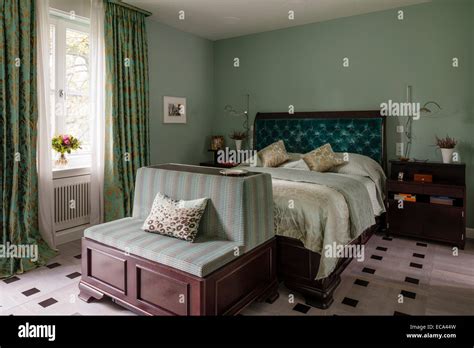 Aquamarine velvet buttoned headboard on bed in bedroom with green and ...