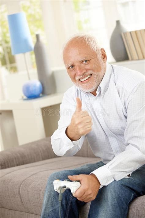 Older man giving thumb up with computer game. Older man sitting on ...