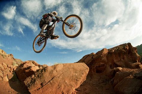 Low angle view of mountain biker performing stunt while cycling stock photo