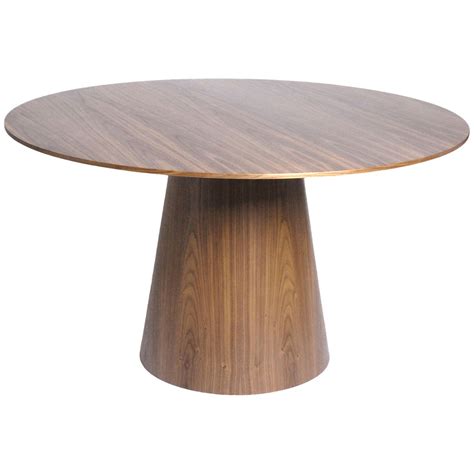 a round wooden table sitting on top of a white floor