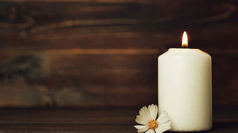 Download A Candle With A Flower On A Wooden Table | Wallpapers.com