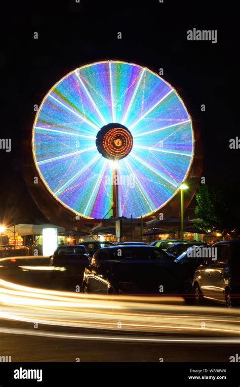 Night view of a Ferris wheel in motion and car trails Stock Photo - Alamy