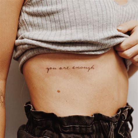 "You are enough" lettering tattoo on the rib