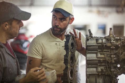 Two men repairing outboard motor in boat repair workshop stock photo