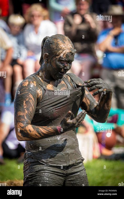 A woman stands covered in mud in the mud wrestling pit at The Lowland ...