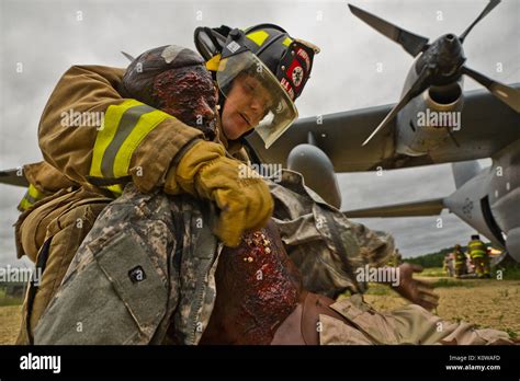 A U.S. Army firefighter lifts a mannequin while responding to a C-130 ...