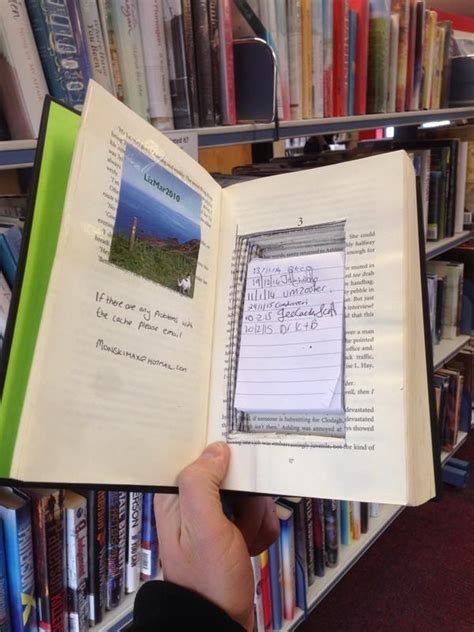 a person holding an open book in front of a bookshelf full of books