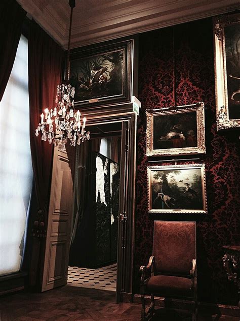 an ornate room with paintings on the wall and a chandelier