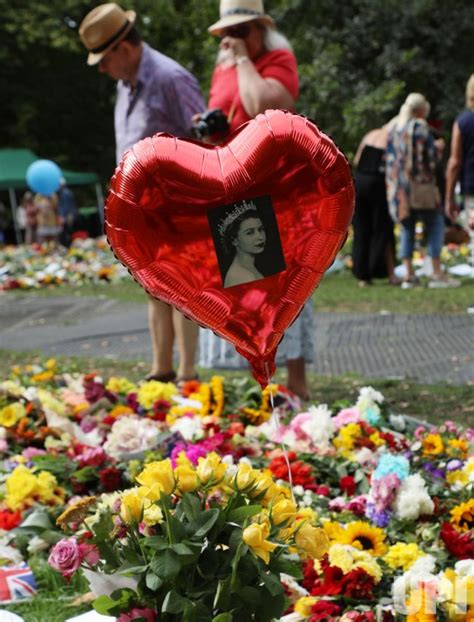 Photo: Members of the public lay flowers in remembrance for Her Majesty ...