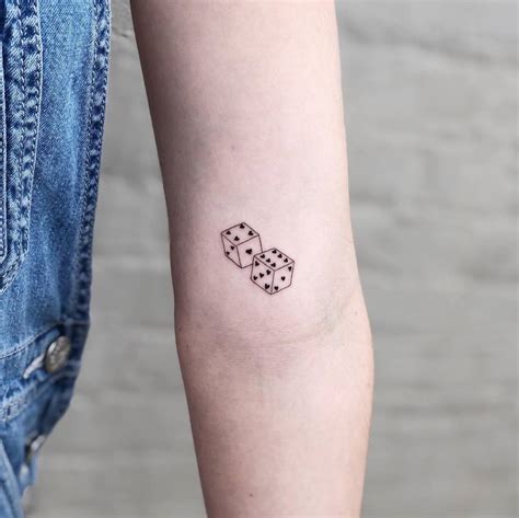 Dice tattoo located on the inner arm, minimalistic