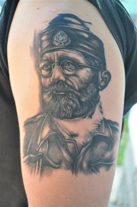 a man with a beard and glasses on his arm is wearing a black and grey ...