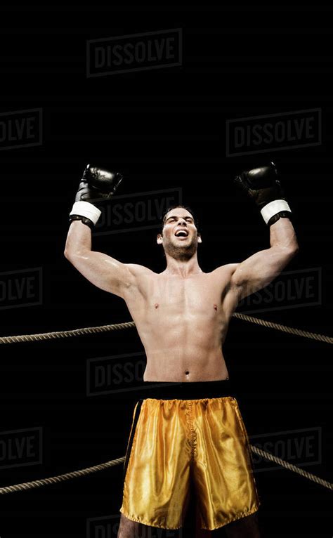 Boxer celebrating in corner of boxing ring - Stock Photo - Dissolve