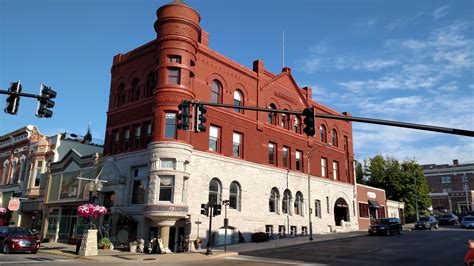 an old red brick building on the corner of a street with traffic lights ...