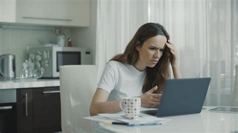 Premium Photo | Angry woman typing on laptop computer at kitchen ...