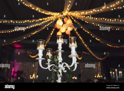 White vintage candelabrum with glass lamps and candles. Ceiling party ...