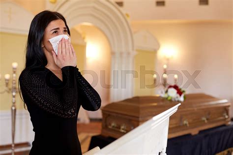 woman with coffin crying at funeral in church | Stock image | Colourbox