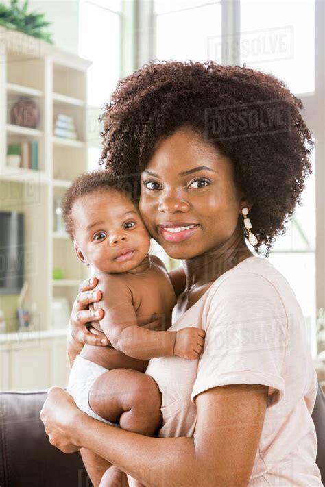 Black mother holding baby son - Stock Photo - Dissolve