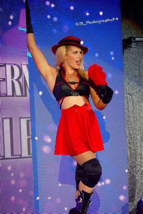 a woman in a red skirt and black top on stage