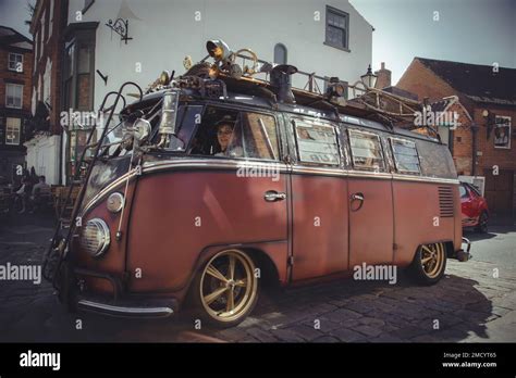 A customised Volkswagen camper van travelling on a cobbled road ...