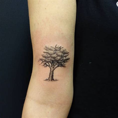 a small tree tattoo on the arm