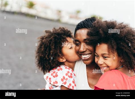 African sisters twins kissing mother on the beach - Main focus on right ...