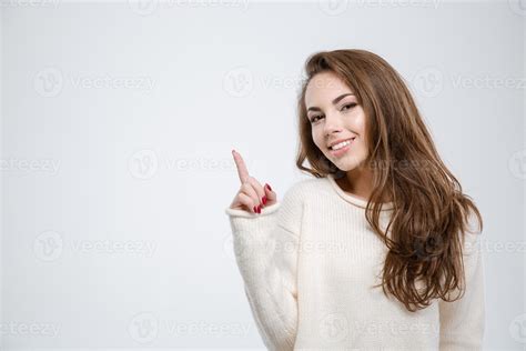 Smiling young woman pointing finger up 1258193 Stock Photo at Vecteezy