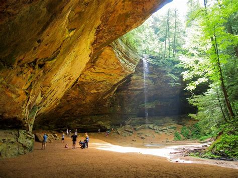 some people are standing in front of a large rock formation with a ...