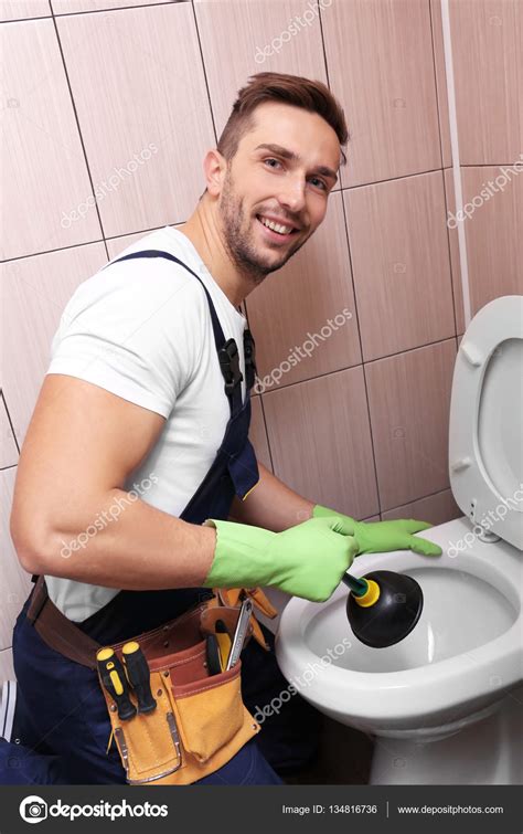 Plumber repairing toilet — Stock Photo © belchonock #134816736