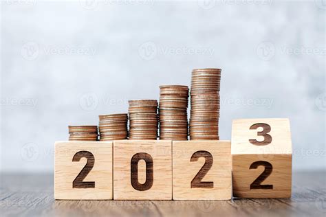 volteando el bloque de 2022 a 2023 años con pila de monedas. conceptos ...