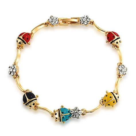 a gold bracelet with ladybugs and crystal stones on the clasp, all in ...