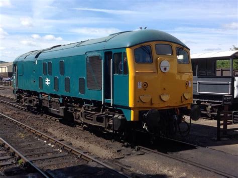 a blue and yellow train sitting on the tracks