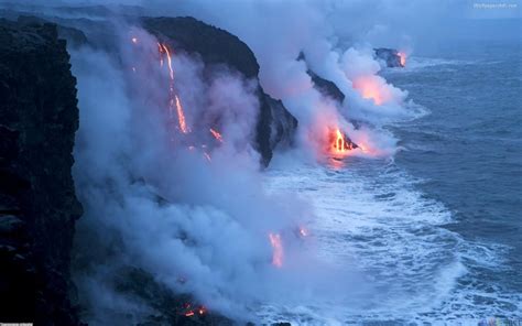 lava flowing into the ocean with red and yellow lights coming from it's ...