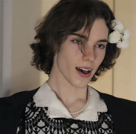 a young woman wearing a black and white dress with a flower in her hair ...