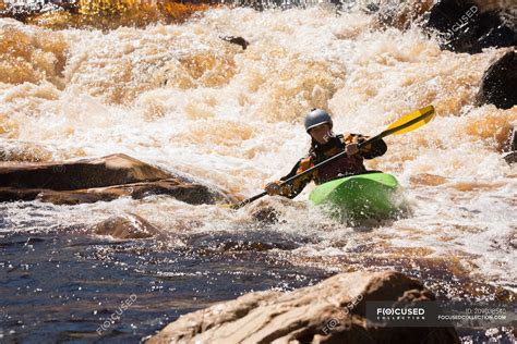 Woman kayaking in mountain river water in sunlight. — outdoors, rocks ...