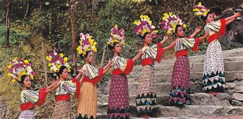 the women are dressed in colorful outfits and holding flowers on their ...