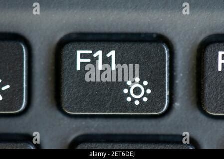 F11 and decrease brightness key on a laptop keyboard Stock Photo - Alamy