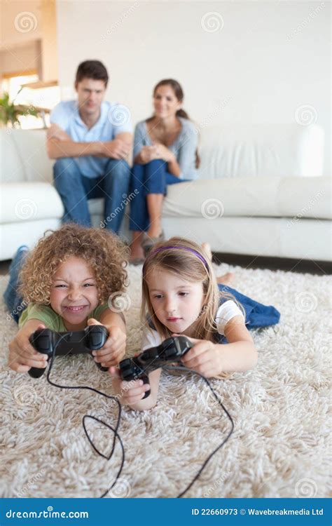 Portrait Of Children Playing Video Games While Their Parents Are Stock ...