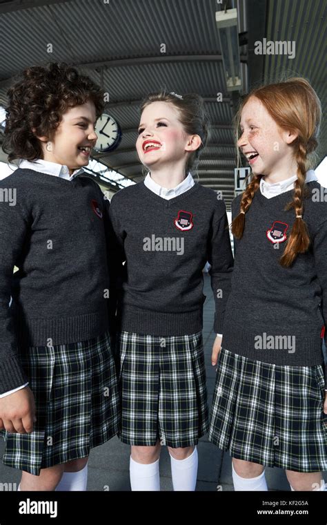 Three girls wearing school uniform talking on platform Stock Photo - Alamy