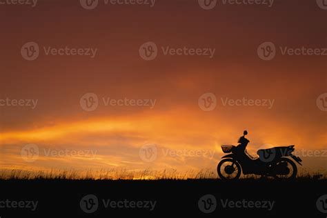 Orange sunset sky. Silhouette motorcycle in sunset landscape backdrop ...